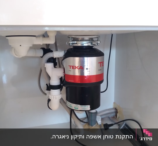 מטחנת אשפה מותקנת מתחת לכיור עם צינורות חיבור